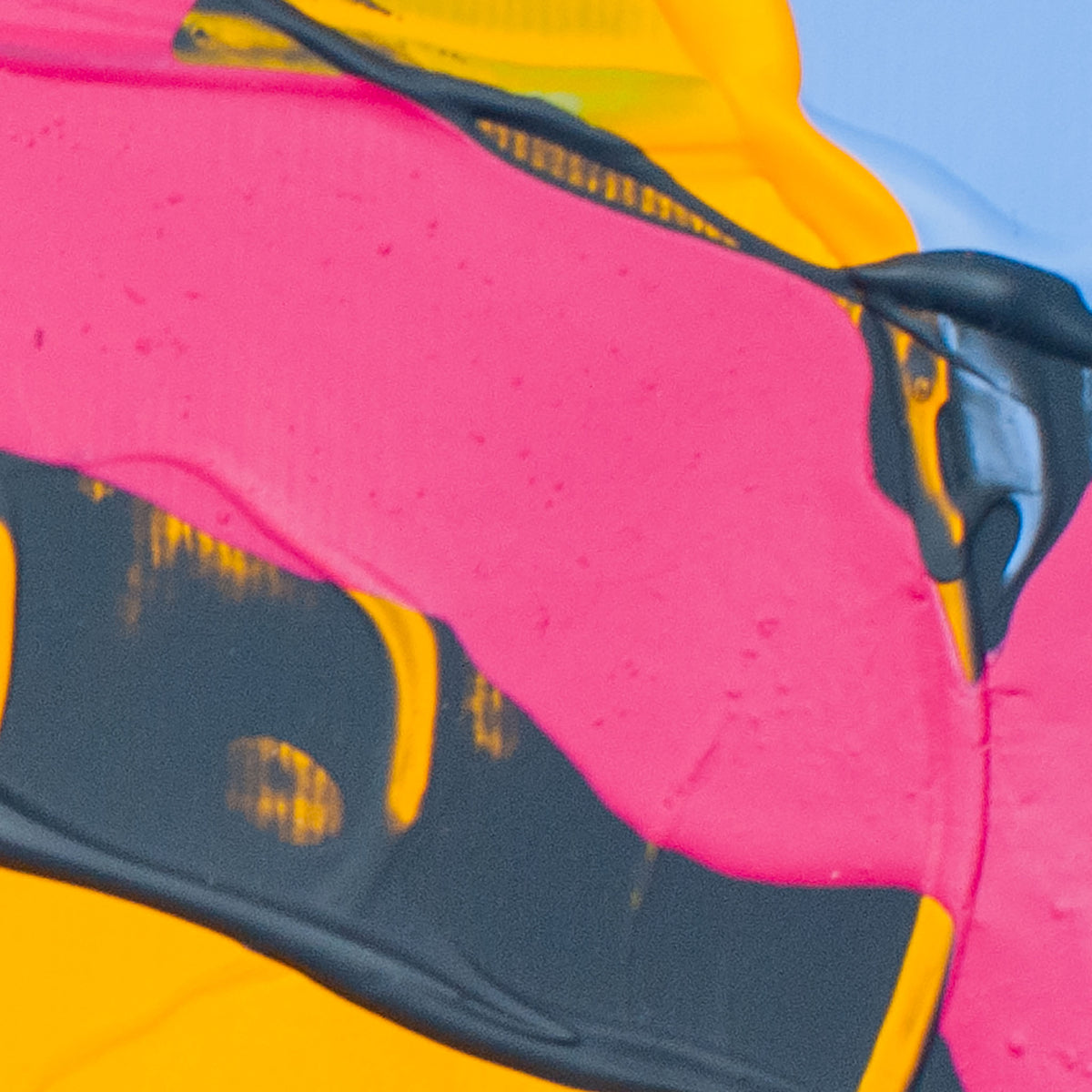 Abstract close-up of a brightly colored surface with large areas of hot pink, yellow, black, and a small patch of light blue.
