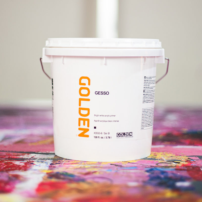 Bucket of Golden gesso on a colourful paint-covered workbench