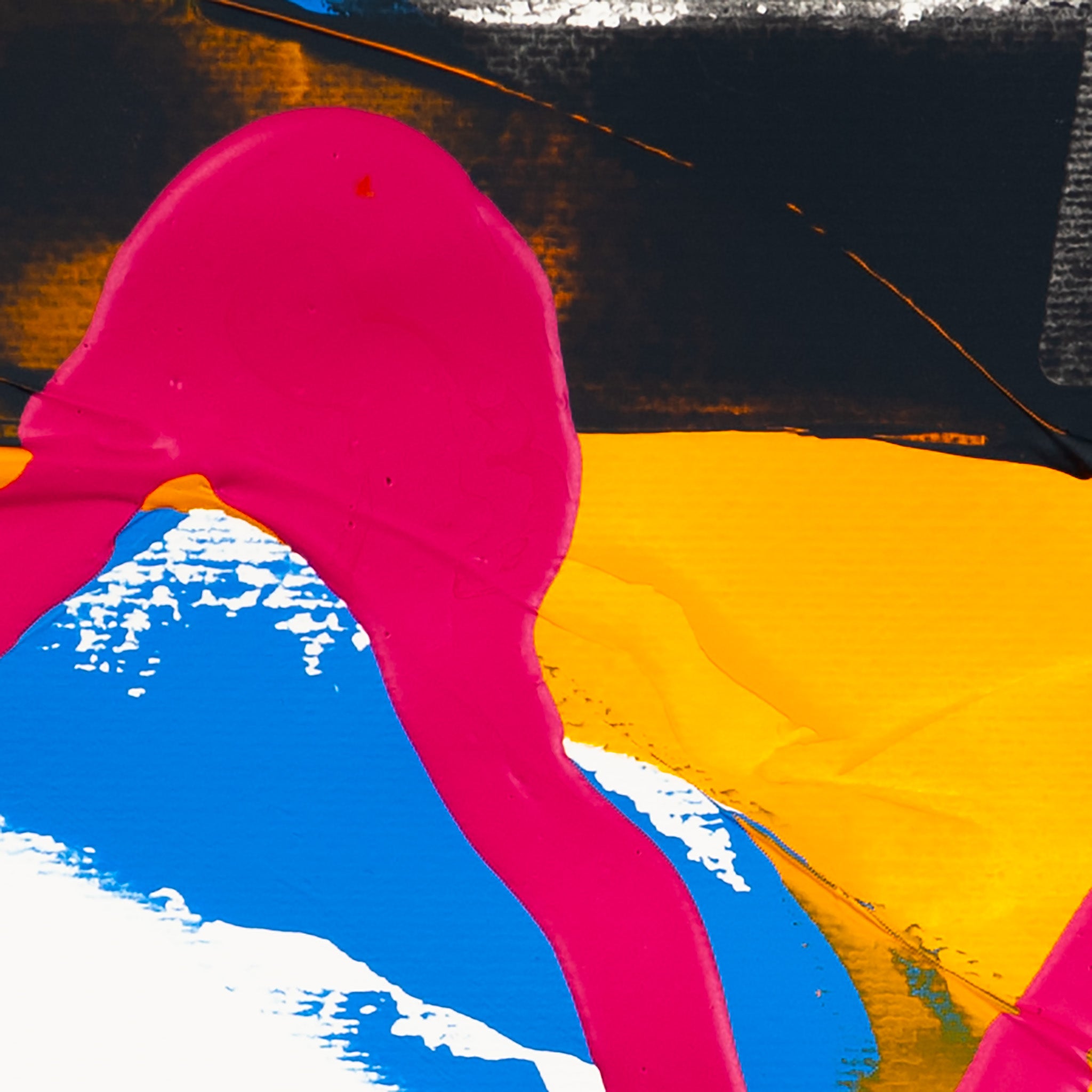 Close-up of matte pink acrylic paint intersecting dark grey textured forms with yellow and blue sections on white paper.