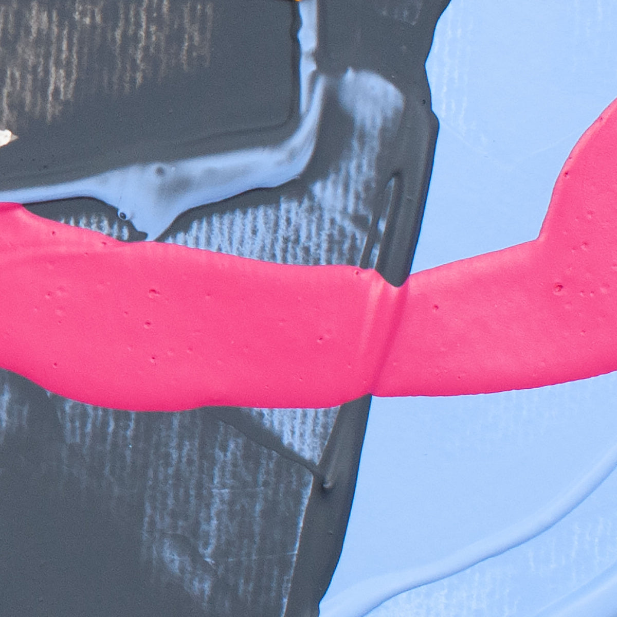 Close-up of an abstract painting with a thick hot pink brushstroke over black and light blue textured paint.