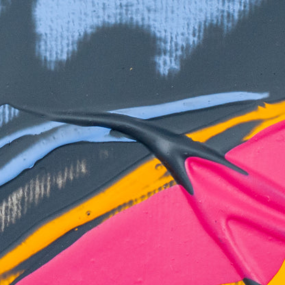 Abstract close-up of layered paint or material with bold areas of bright pink, black, light blue, and orange on a dark charcoal background.