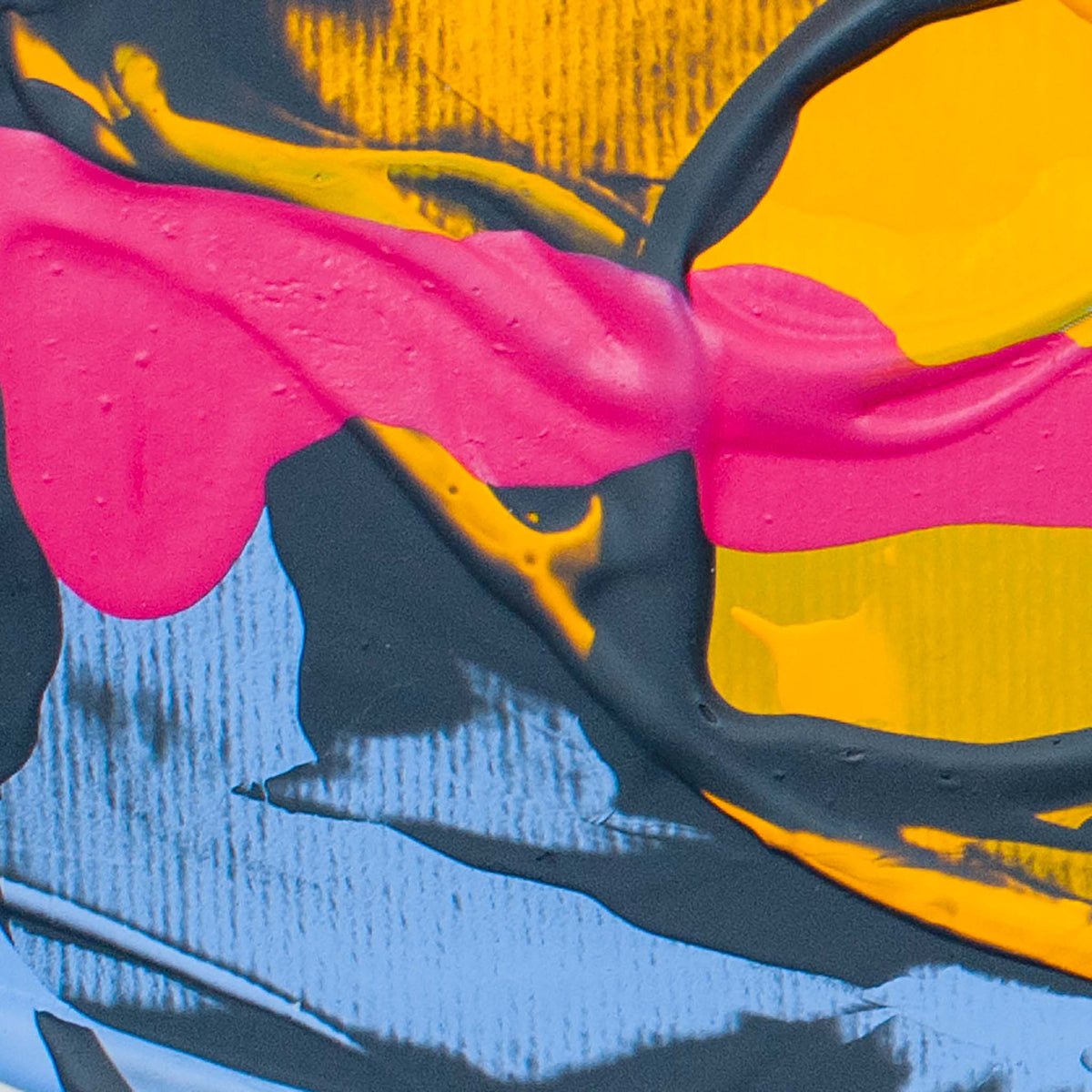 Abstract close-up of a colorful textured surface with bold pink, yellow, blue, black, and gray paint-like areas.