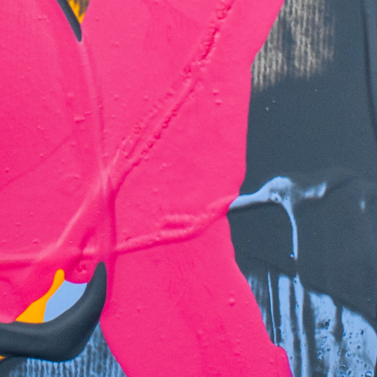 Close-up of a bright pink textured surface with a dripping paint effect over a dark charcoal background, with small yellow and blue accents visible at the edges.