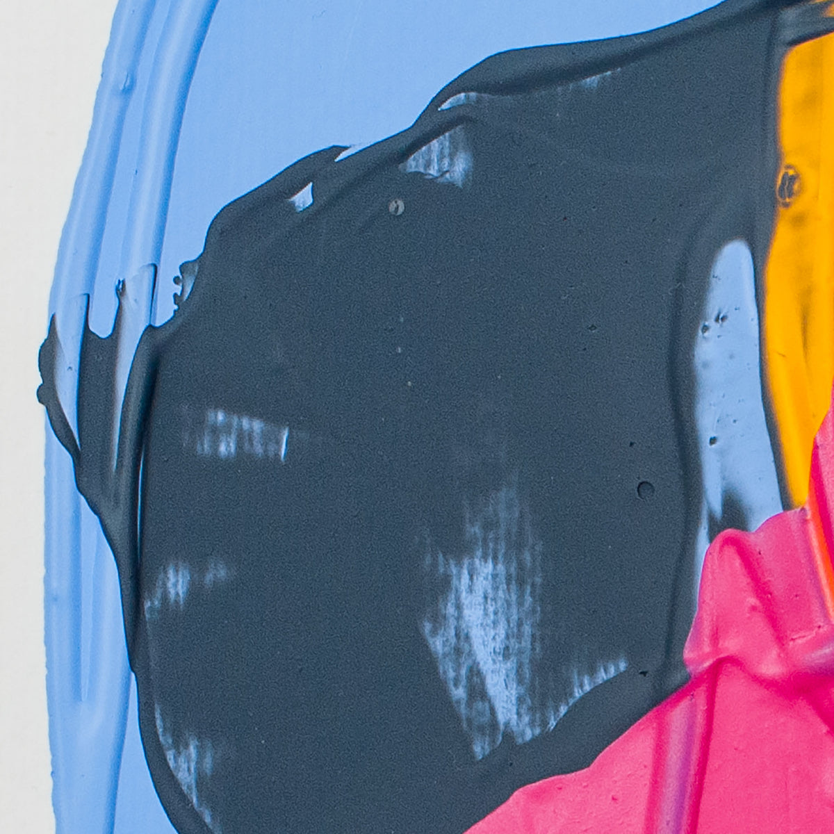 A close-up of thick, glossy black paint dripping over a bright blue surface, with a section of vivid pink and yellow visible at the lower right.