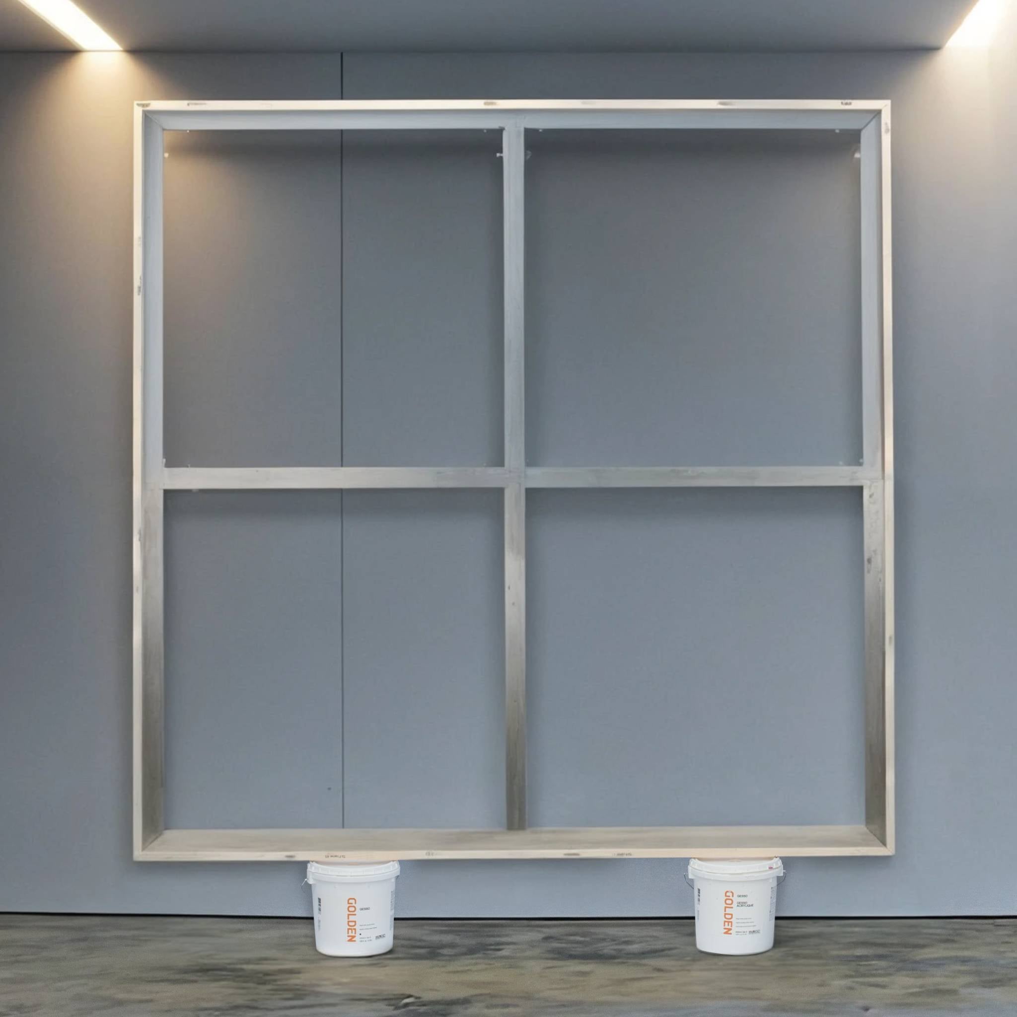 Large aluminium stretcher bar frame resting on paint buckets in a studio