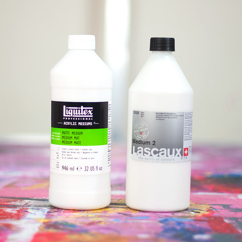 Liquitex and Lascaux matt medium bottles on a colourful paint-covered workbench
